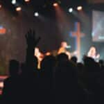 A vibrant church music band performing on stage with guitars and singers.