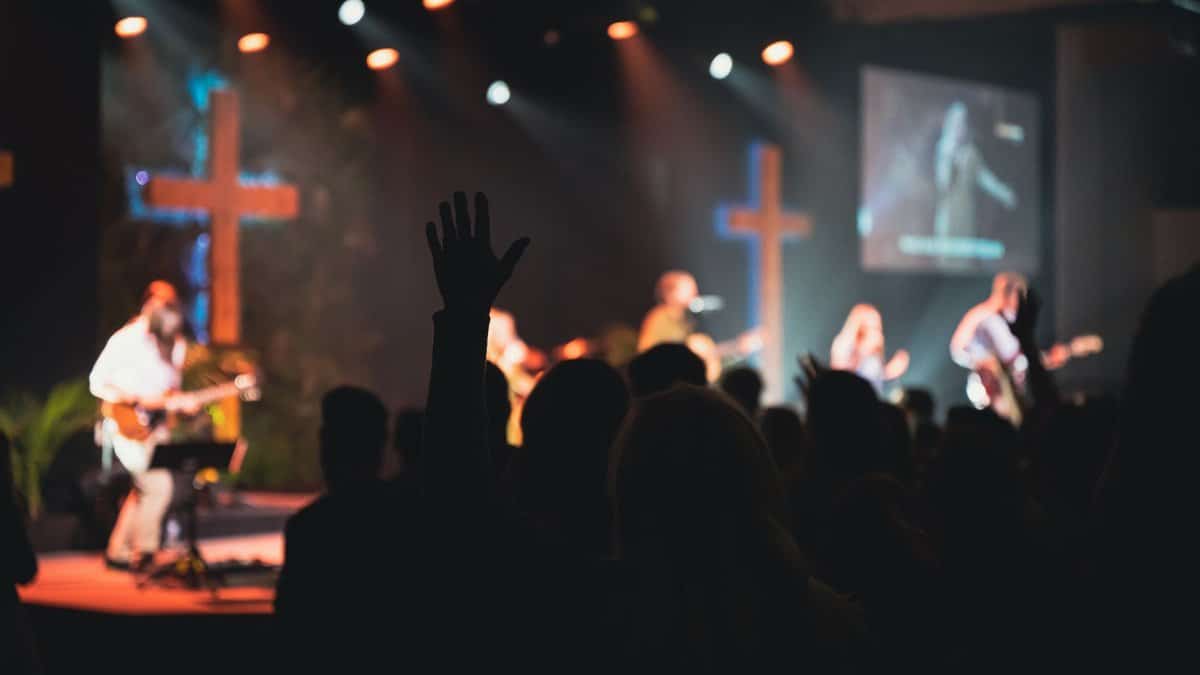A vibrant church music band performing on stage with guitars and singers.