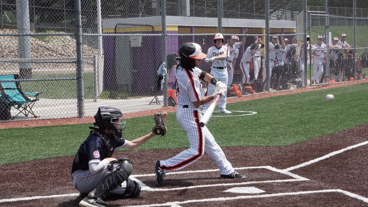 A thrilling moment on the baseball field capturing the batter hitting the ball, with players in the background.