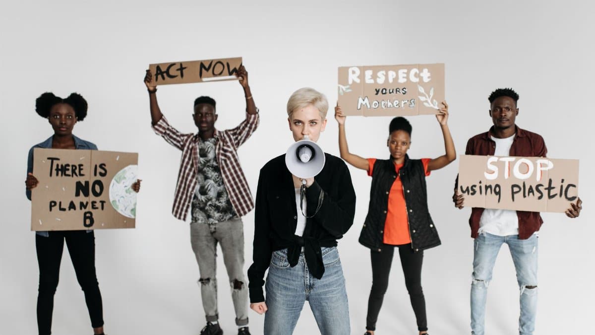 Diverse group of young activists protesting with placards against environmental issues, demanding urgent action.
