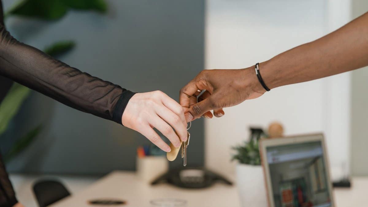 Professional office setting showing a key exchange symbolizing a business deal or real estate transaction.