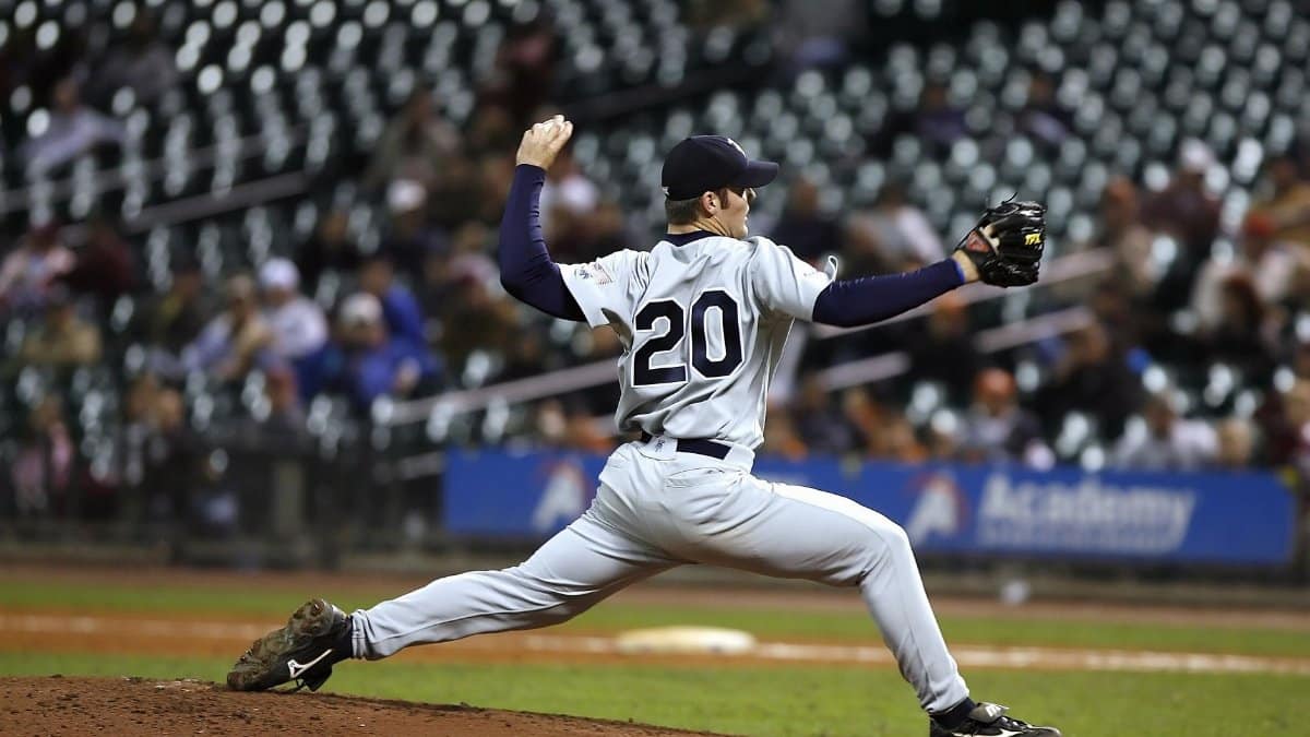 Baseball player pitching on field during a game, showcasing athletic action and focus.