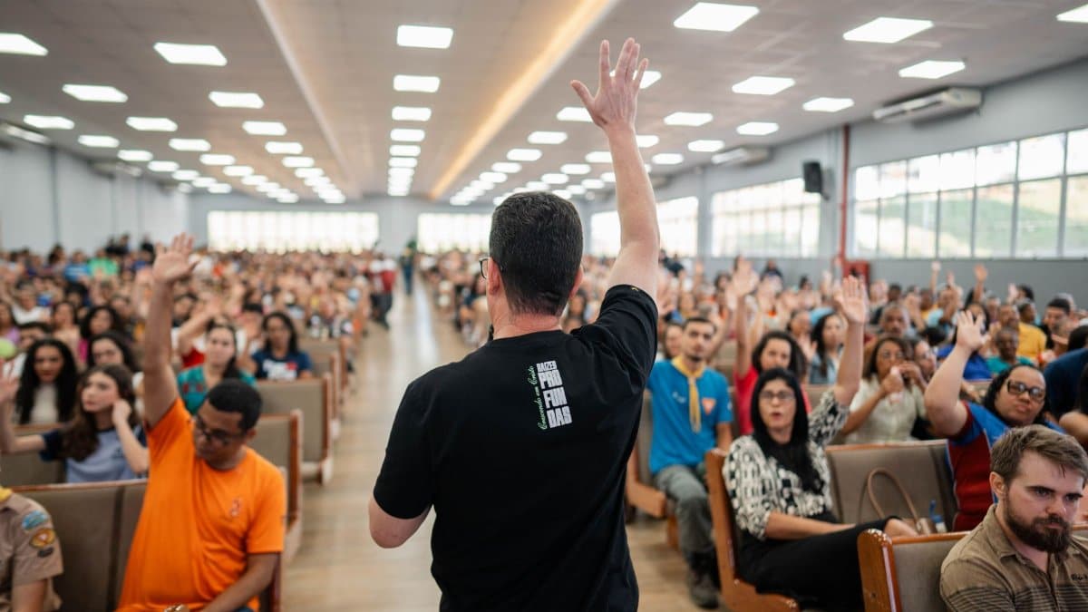 Speaker leads interactive session in packed auditorium with diverse audience.