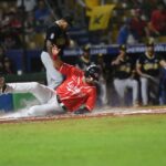 Sliding baseball player during an exciting game in Santo Domingo stadium.