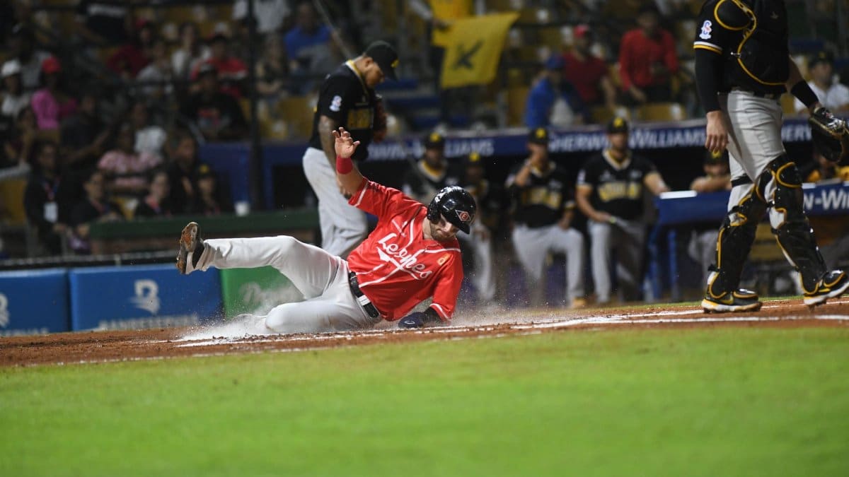 Sliding baseball player during an exciting game in Santo Domingo stadium.