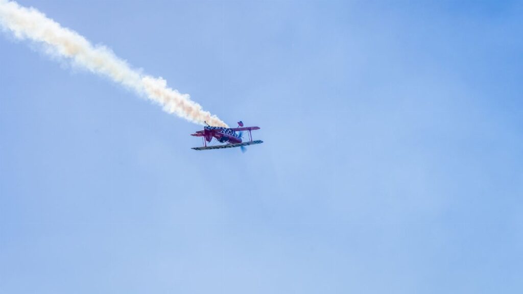 Aerobatic airplane flying with smoke trail during airshow in Buenos Aires, Argentina.