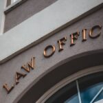 Low angle view of a modern law office exterior with elegant facade and arched entrance.
