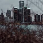 Dramatic view of the Detroit skyline across the waterfront at dusk, featuring skyscrapers.