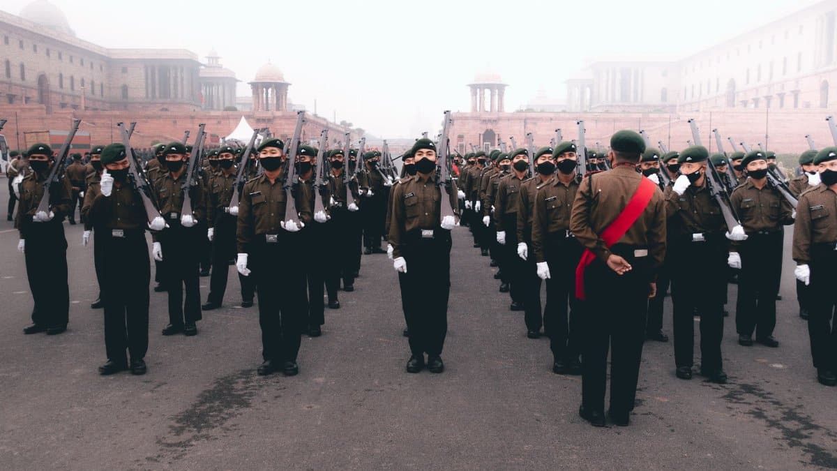 Soldiers in formation during a foggy military parade with uniforms and rifles.