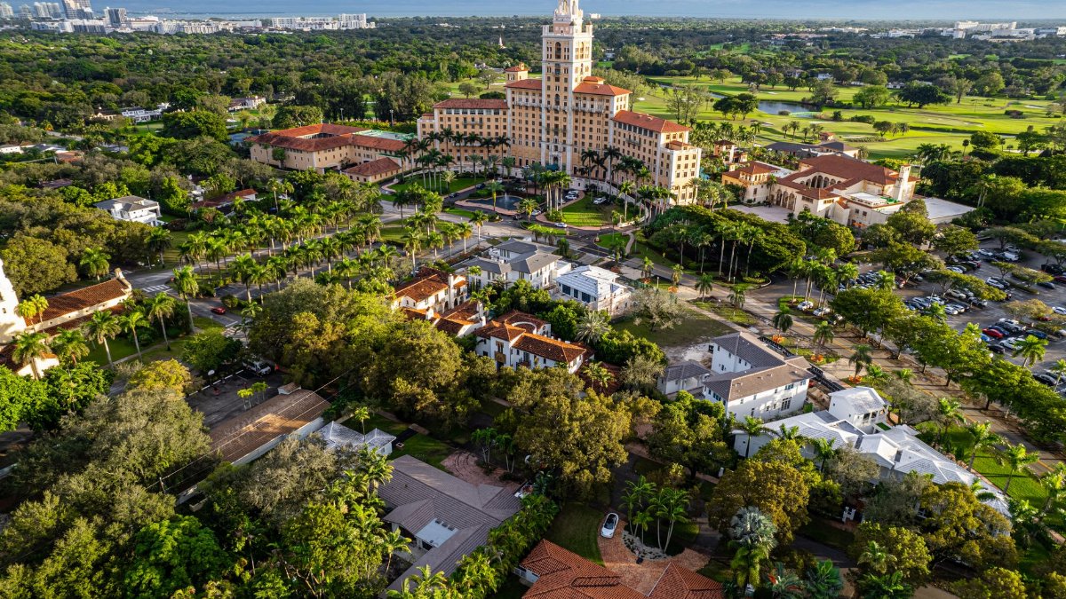 Stunning aerial shot of a luxury hotel in Miami surrounded by lush greenery and urban landscape.