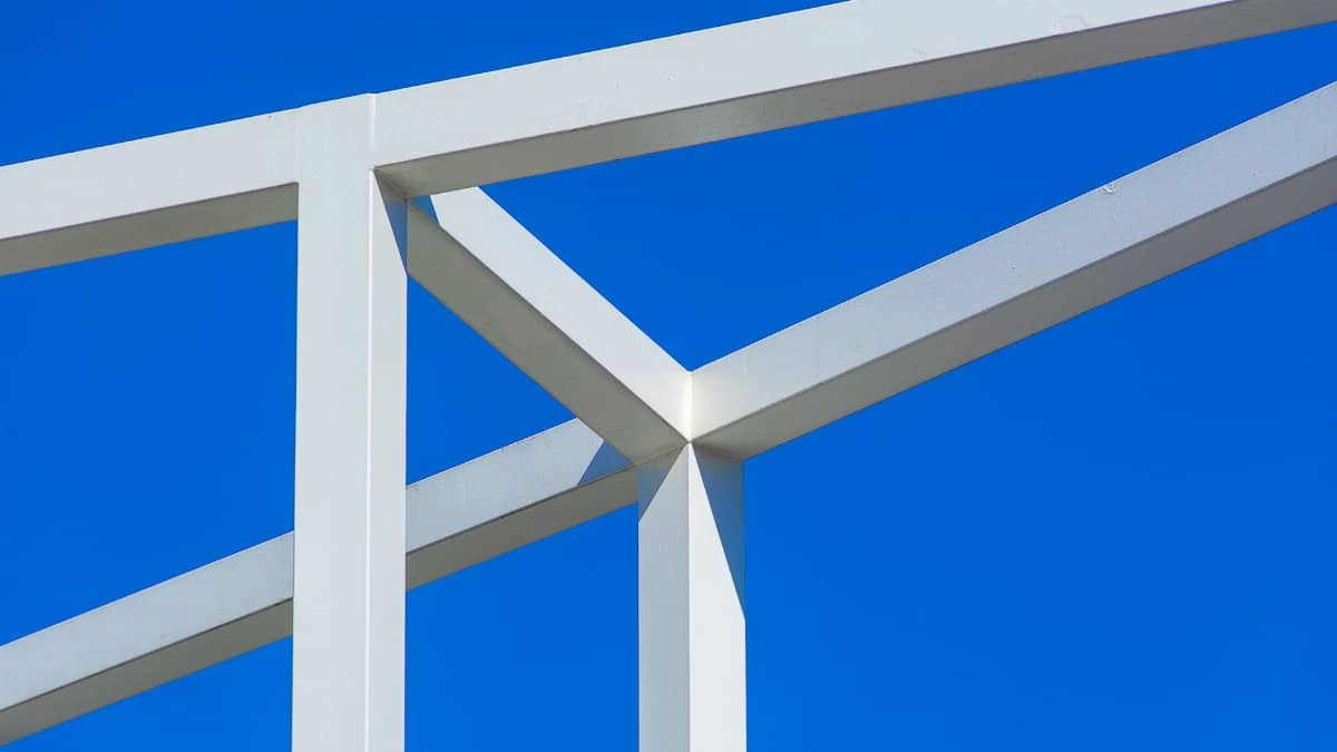 Close-up of a modern metal structure with clean lines against a bright blue sky.