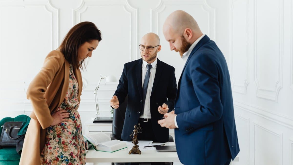 A lawyer meets with clients to discuss legal matters in a professional office setting.