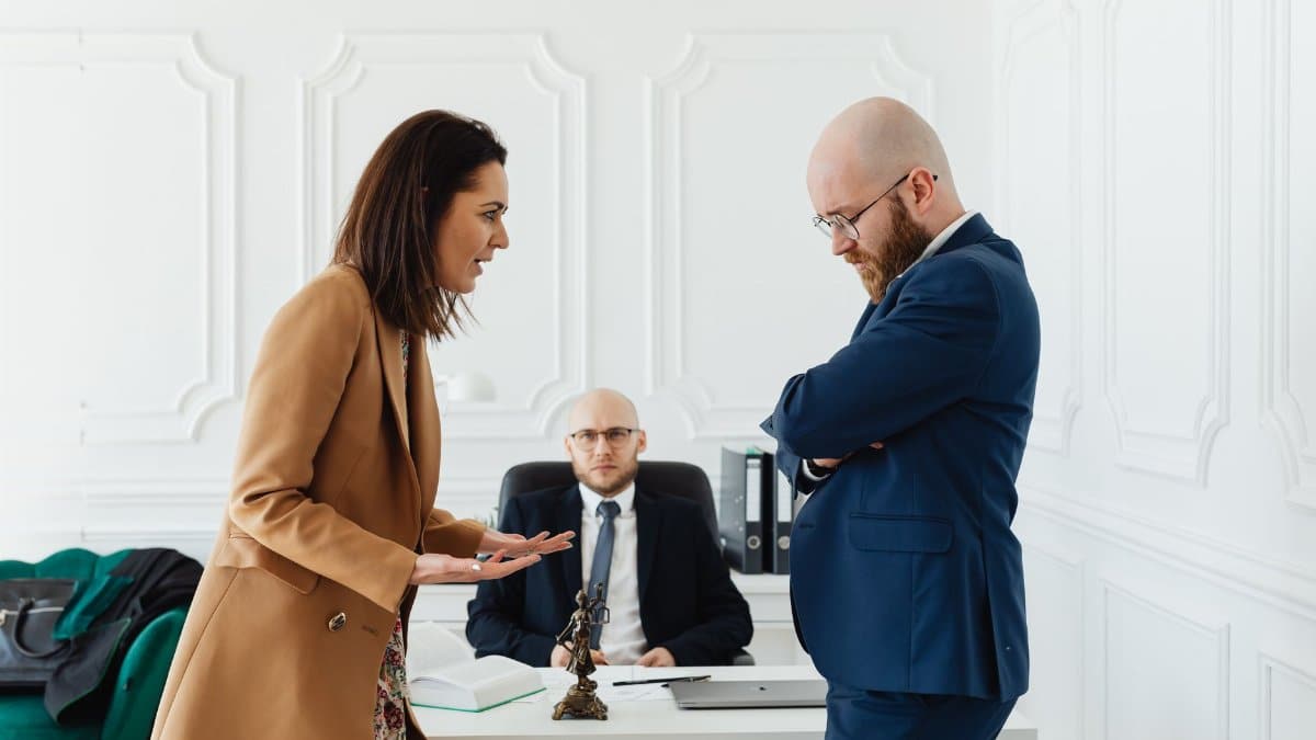 Business professionals engaged in a serious office meeting discussing legal matters.