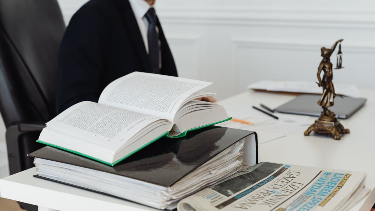 A lawyer sitting at a desk with legal books, documents, and a newspaper, embodying professionalism.