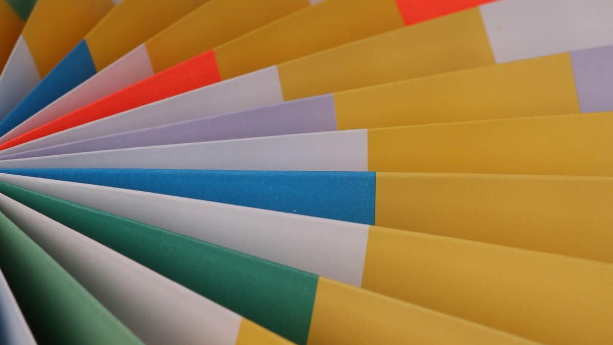 Vibrant folded paper fan displaying a spectrum of colors in an abstract design.