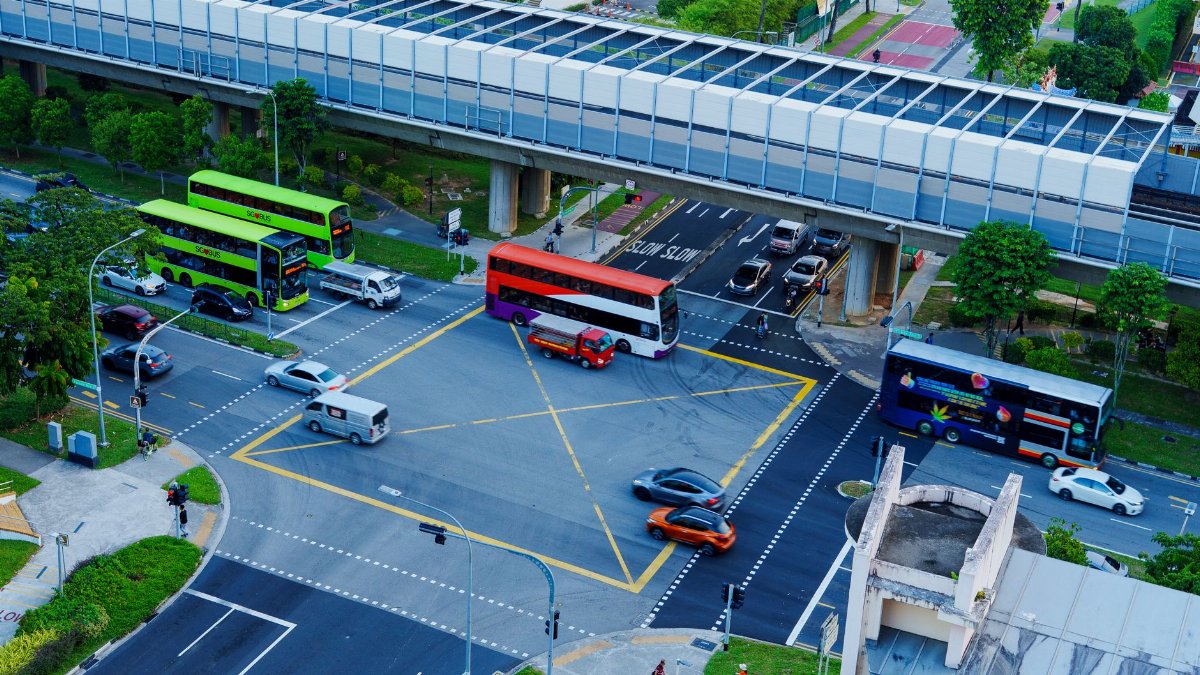 High angle view of a busy intersection with buses and cars in a cityscape setting.