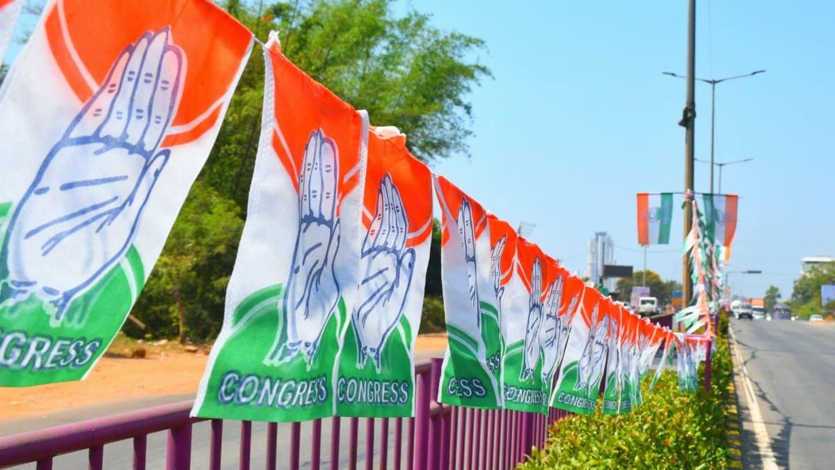 Congress party flags hanging on a roadside railing in Mangaluru, India, symbolizing political promotion.