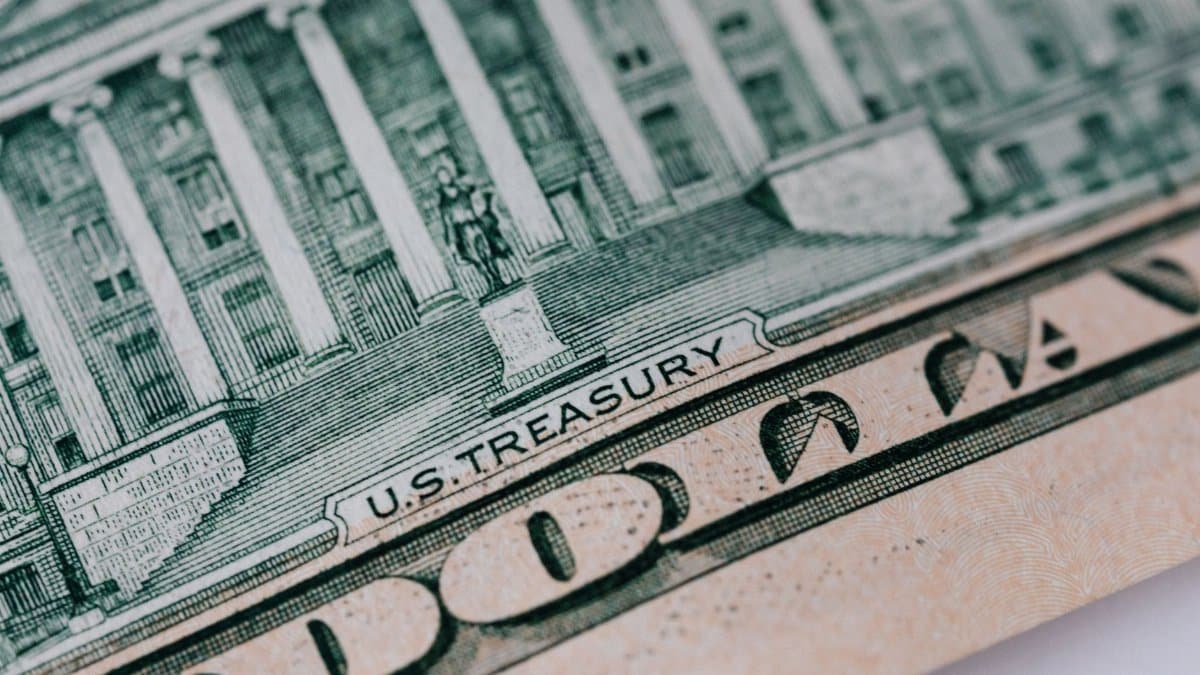 From above ten dollar banknote with inscription and United States treasury building placed on table