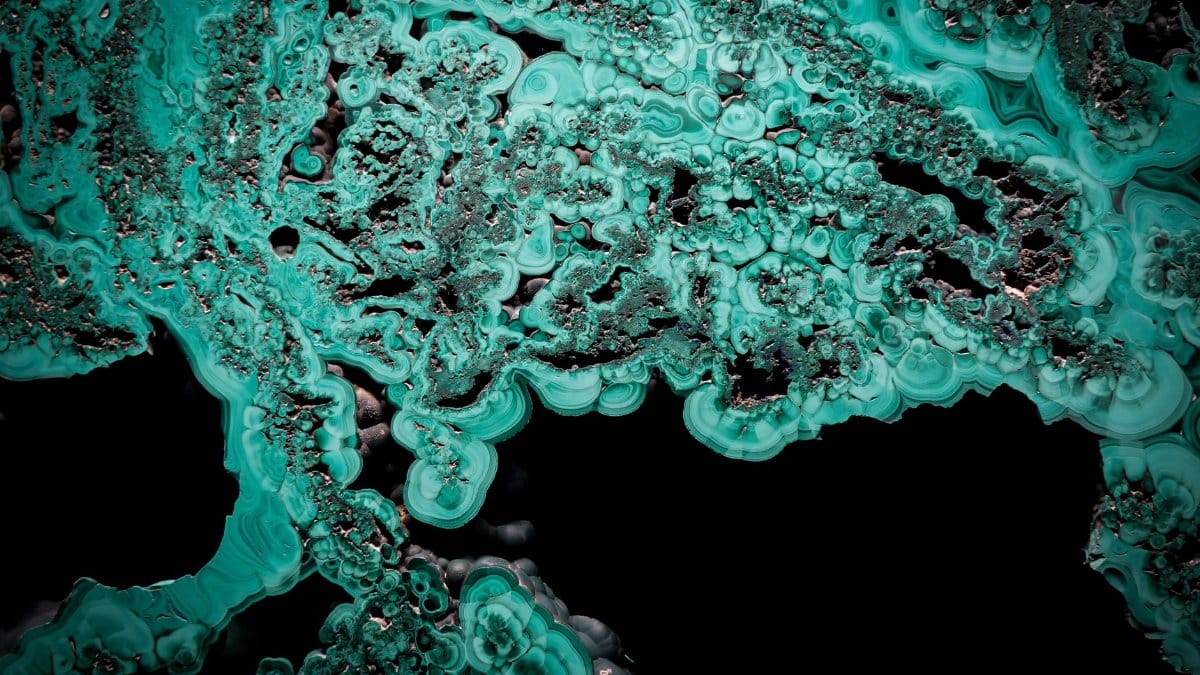 Abstract image showing intricate malachite patterns and textures in vivid green.