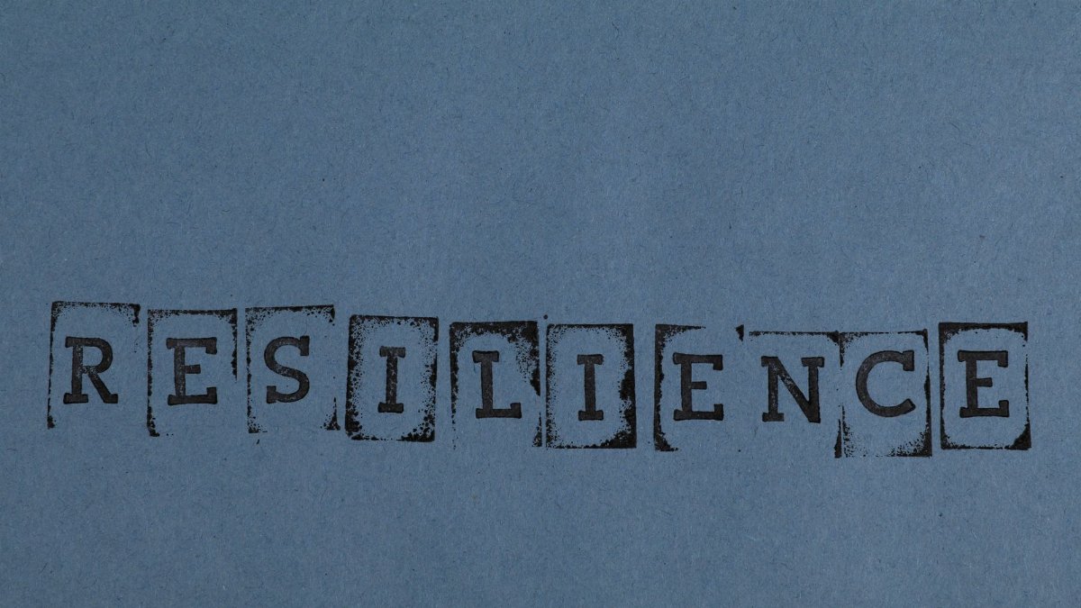 RESILIENCE printed in vintage style on a textured blue background paper.