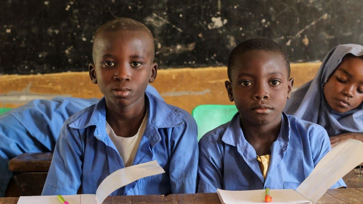 Children in a rural classroom setting focused on their studies, showcasing educational diversity.