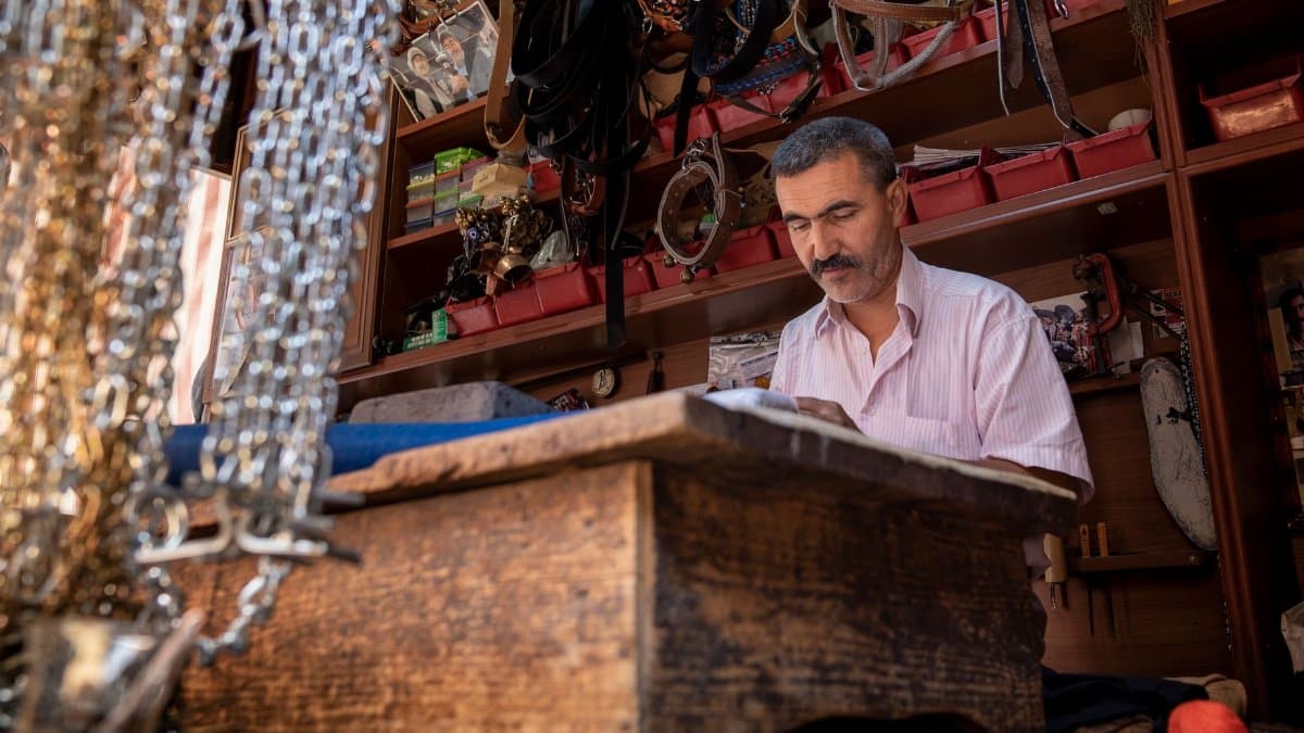 A skilled artisan focuses on crafting in a vibrant shop in Ödemiş, İzmir, capturing a slice of local culture.
