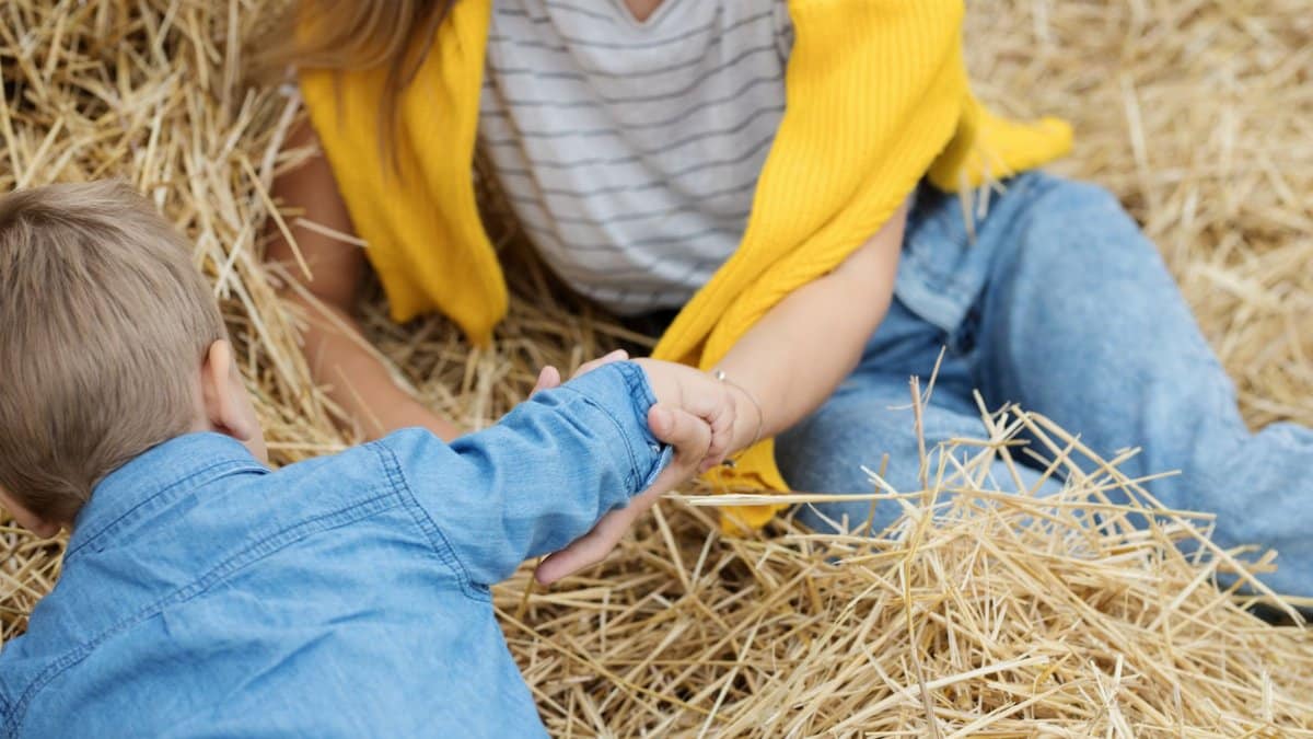 Mother and son bonding in a straw field, creating a heartwarming and warm family moment.