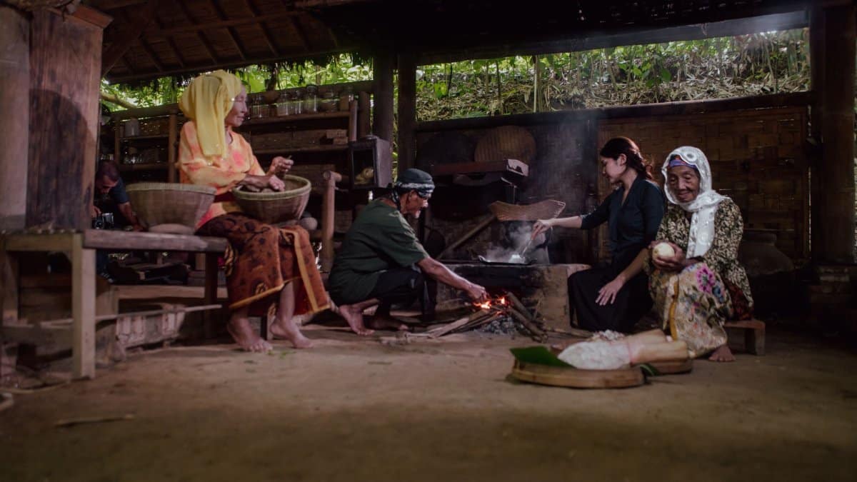 A group of people cooking using traditional methods in Malang, Indonesia, showcasing cultural heritage.