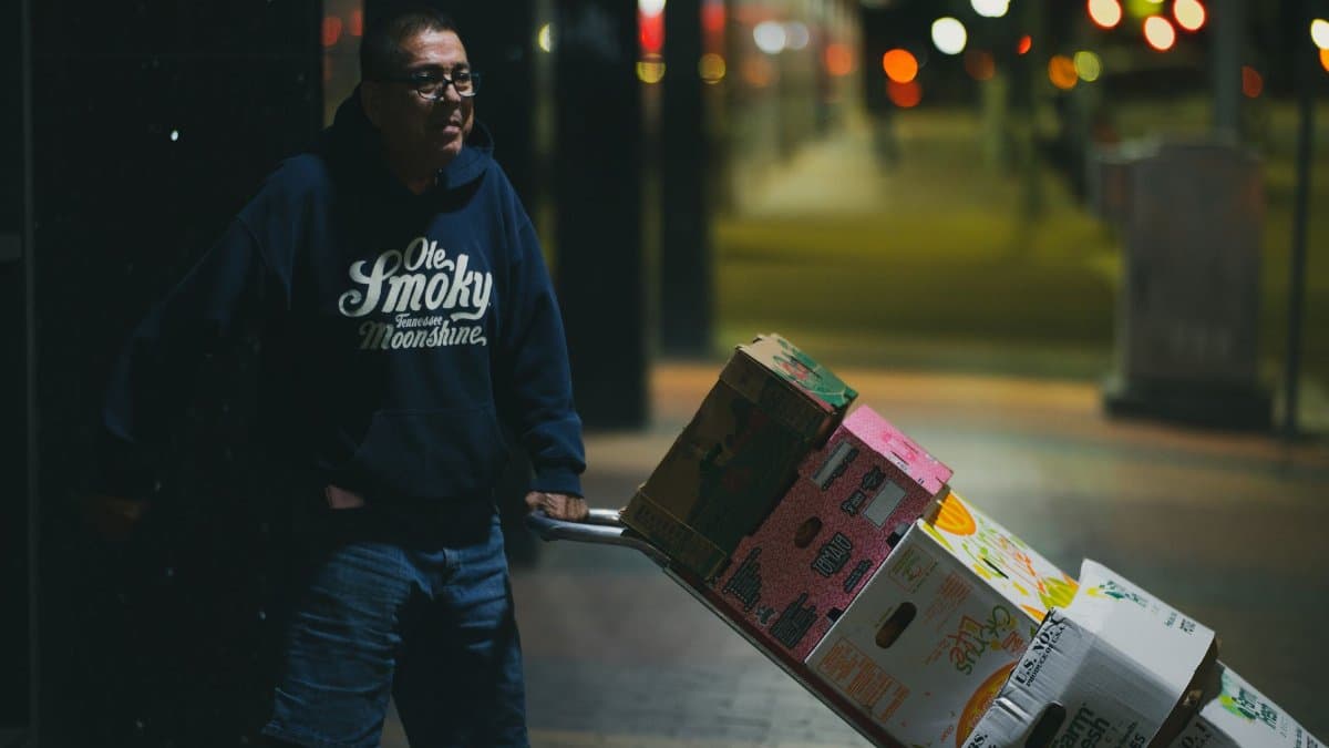 Candid street photo of a person pushing a cart at night in Houston, TX.