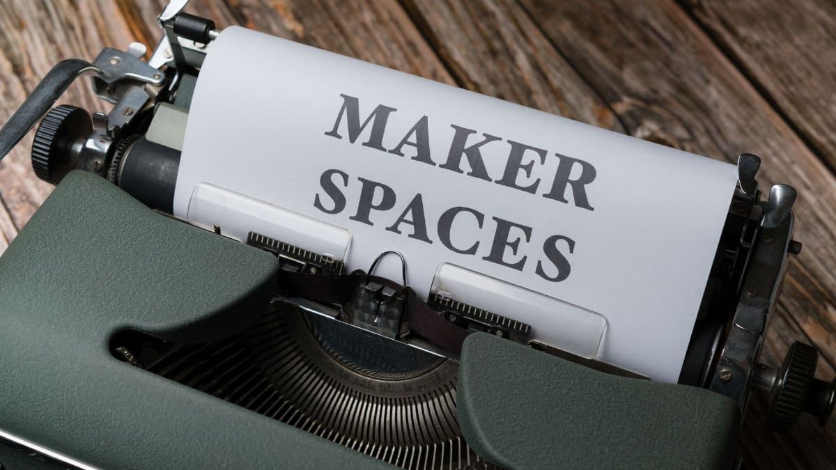 Close-up of a vintage typewriter with a paper reading 'Maker Spaces', signifying creativity and innovation.
