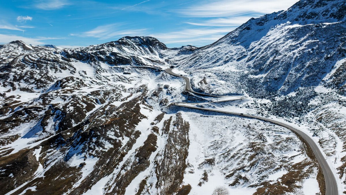 Scenic aerial view of snow-covered mountains and winding road in Kärnten, Austria.