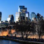 Iconic London skyline view featuring the Tower of London and modern skyscrapers at dusk.