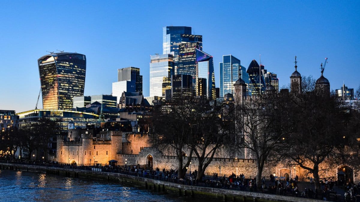 Iconic London skyline view featuring the Tower of London and modern skyscrapers at dusk.