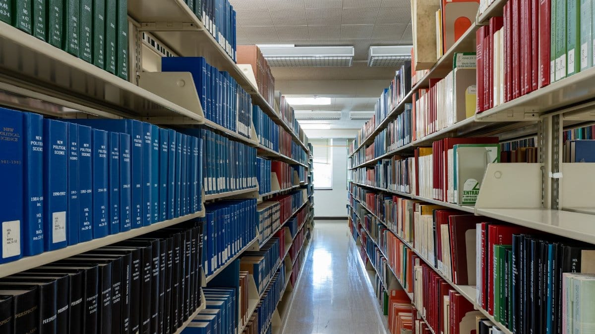 Wide aisle of bookshelves in an academic library at Washington State University.