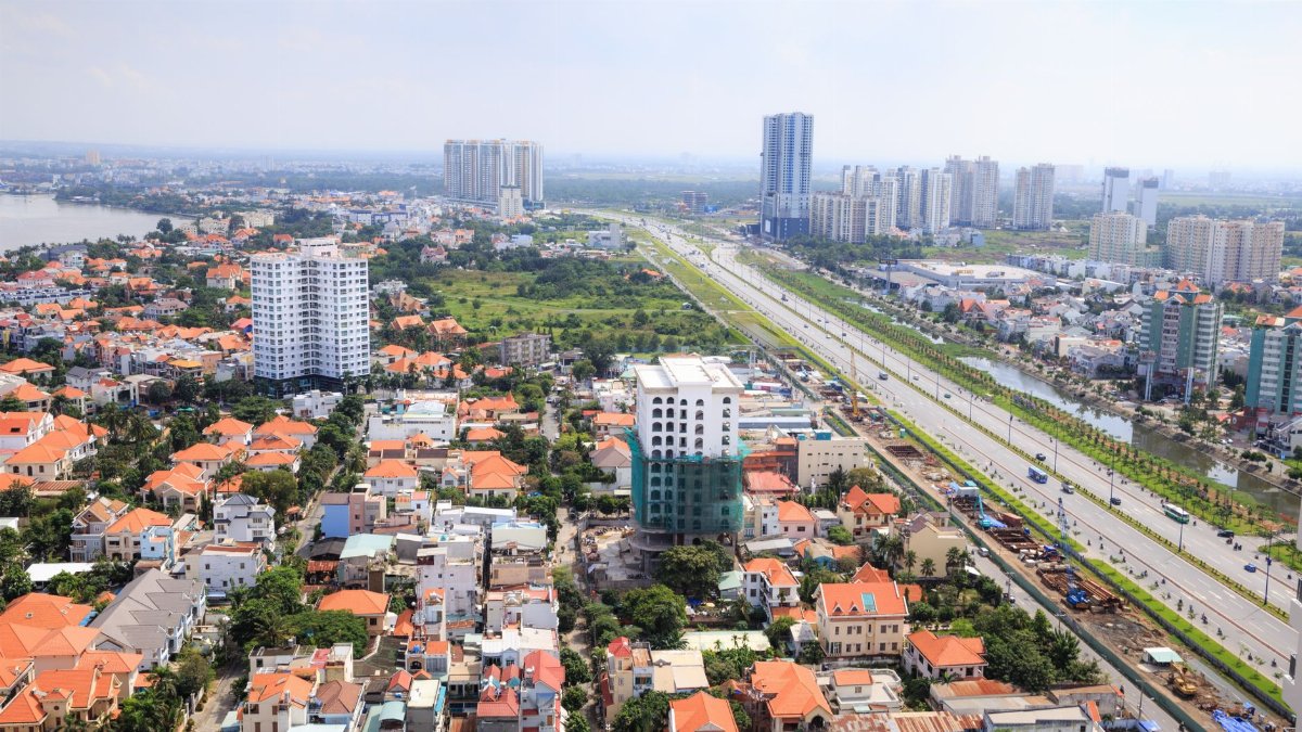A vibrant aerial view showcasing an urban skyline with orange roofs and highways stretching across the cityscape.