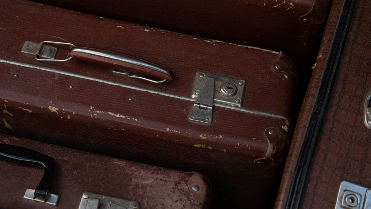 Detailed view of stacked vintage brown suitcases showcasing their classic design and wear.