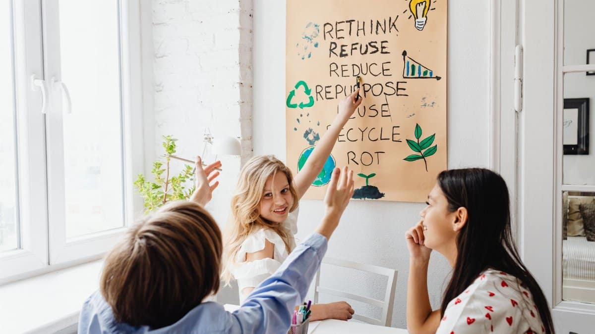 Three teenagers discussing a zero waste project in a bright room, emphasizing sustainability education.