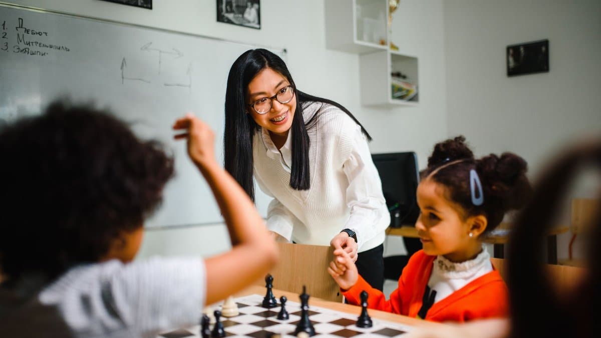 Engaging classroom scene with teacher guiding children in a chess game, fostering learning and fun.