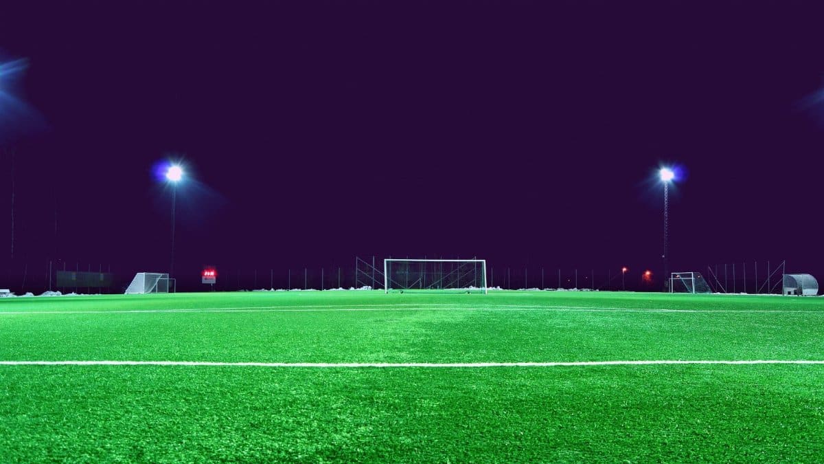 A brightly lit soccer field at night in Norrtälje, Sweden, showcasing green turf and stadium lights.