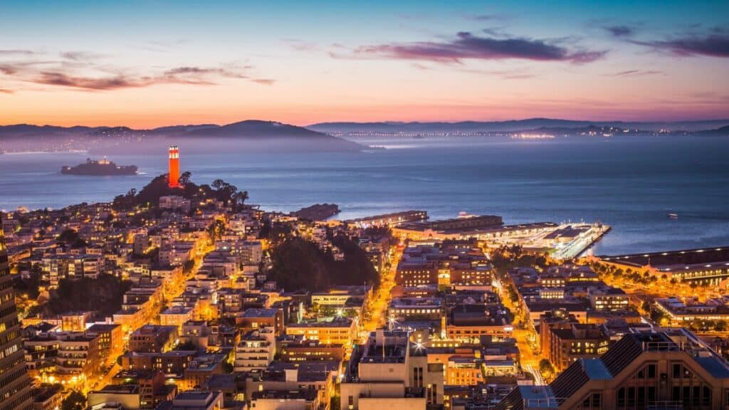 A breathtaking view of San Francisco's skyline and bay at dusk with city lights aglow.