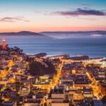 A breathtaking view of San Francisco's skyline and bay at dusk with city lights aglow.