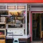 A charming storefront with vintage furniture and shop window on a city sidewalk.