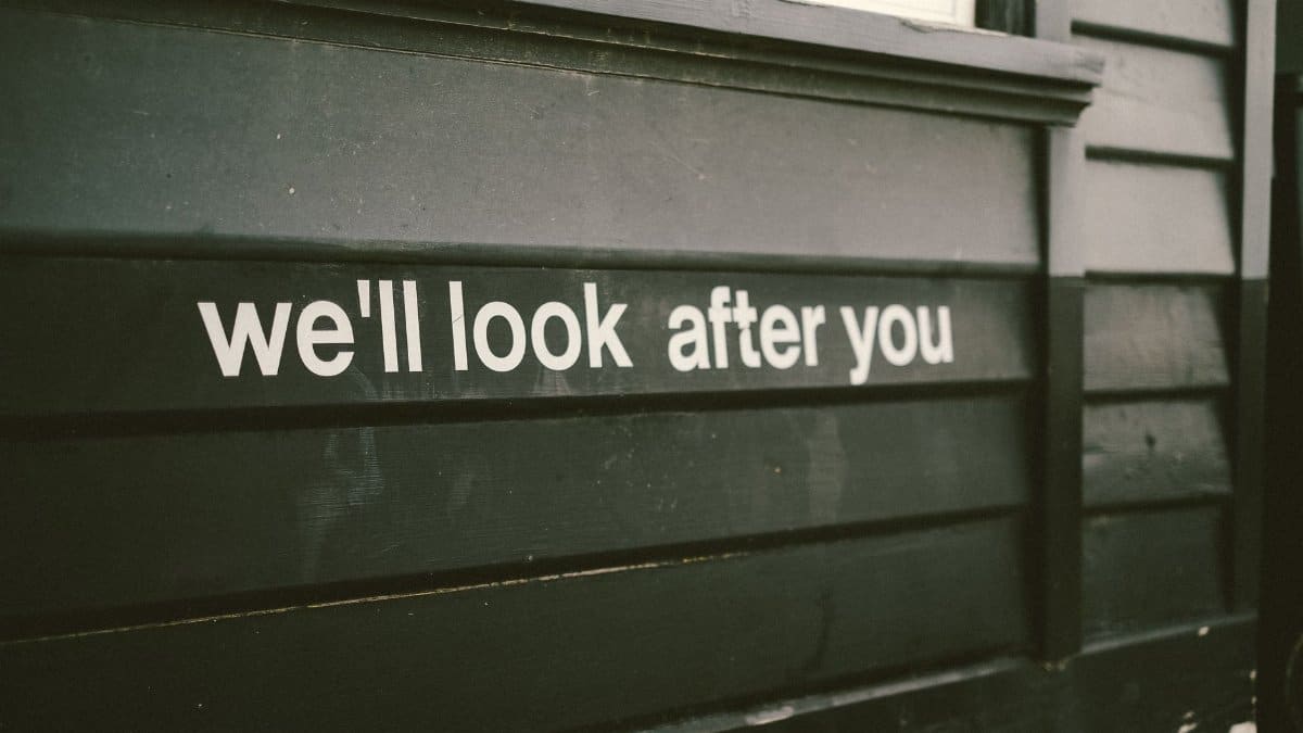 Close-up of a wooden facade with the positive message 'We'll look after you.'