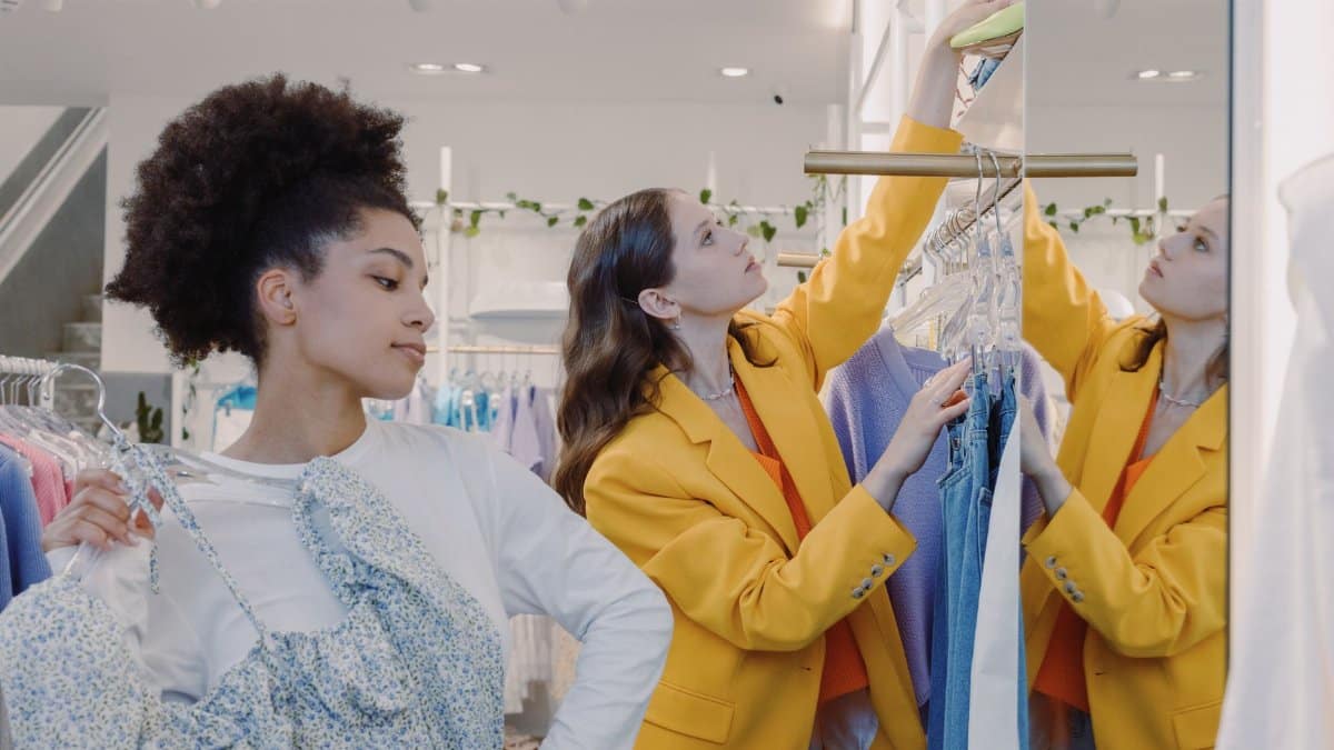 Two women shopping for trendy clothes in a stylish boutique, enjoying a fashionable retail experience.