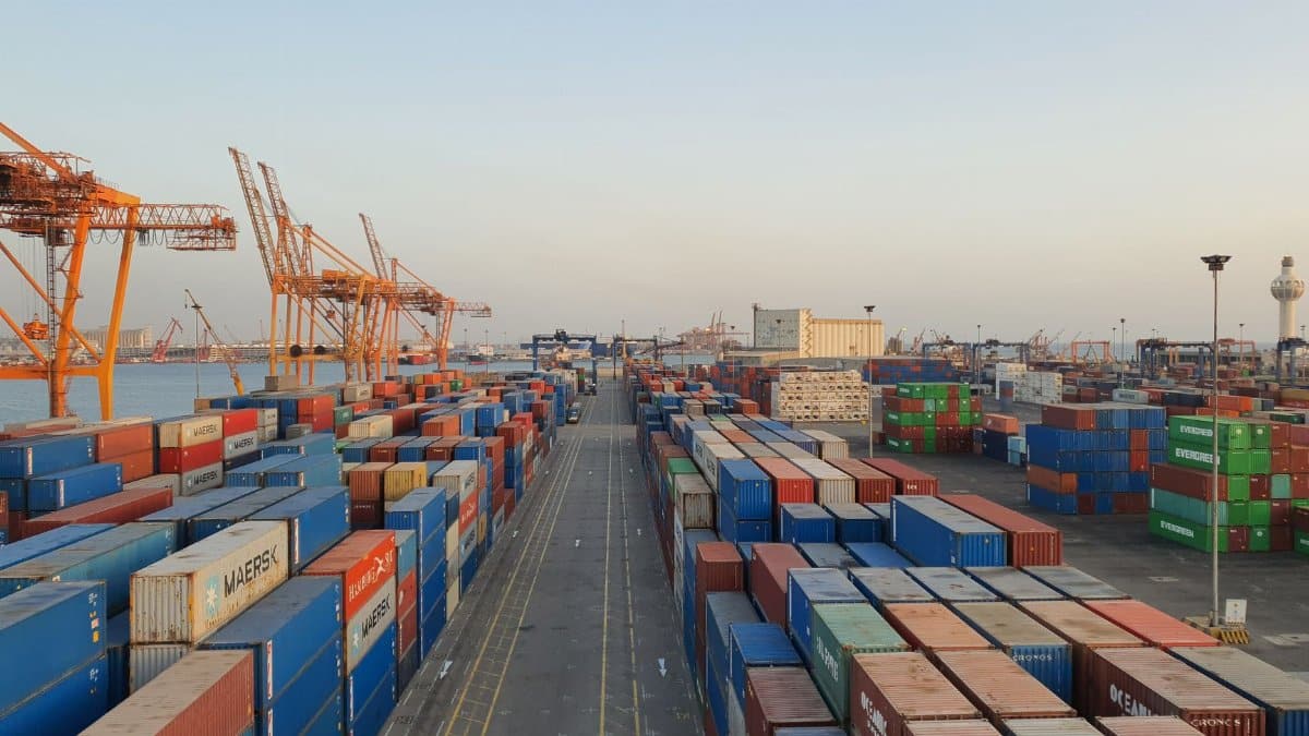A bustling port scene with colorful cargo containers at sunrise. Ideal for logistics concepts.