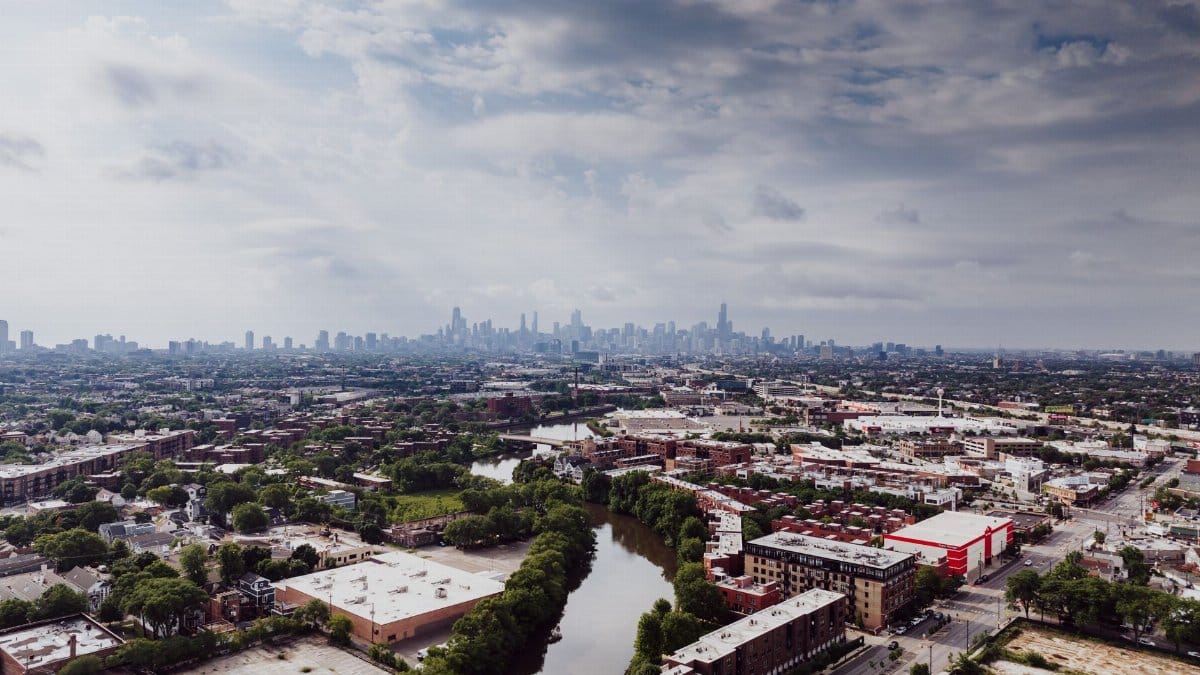 Stunning aerial view of Chicago skyline with urban and suburban landscapes, featuring a serene river.