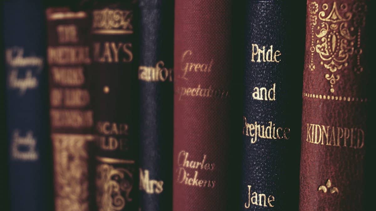 Vintage classic literature books lined up neatly on a bookshelf