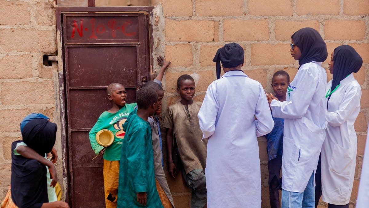 Healthcare workers engage with children in Gombe, Nigeria, promoting community health awareness.