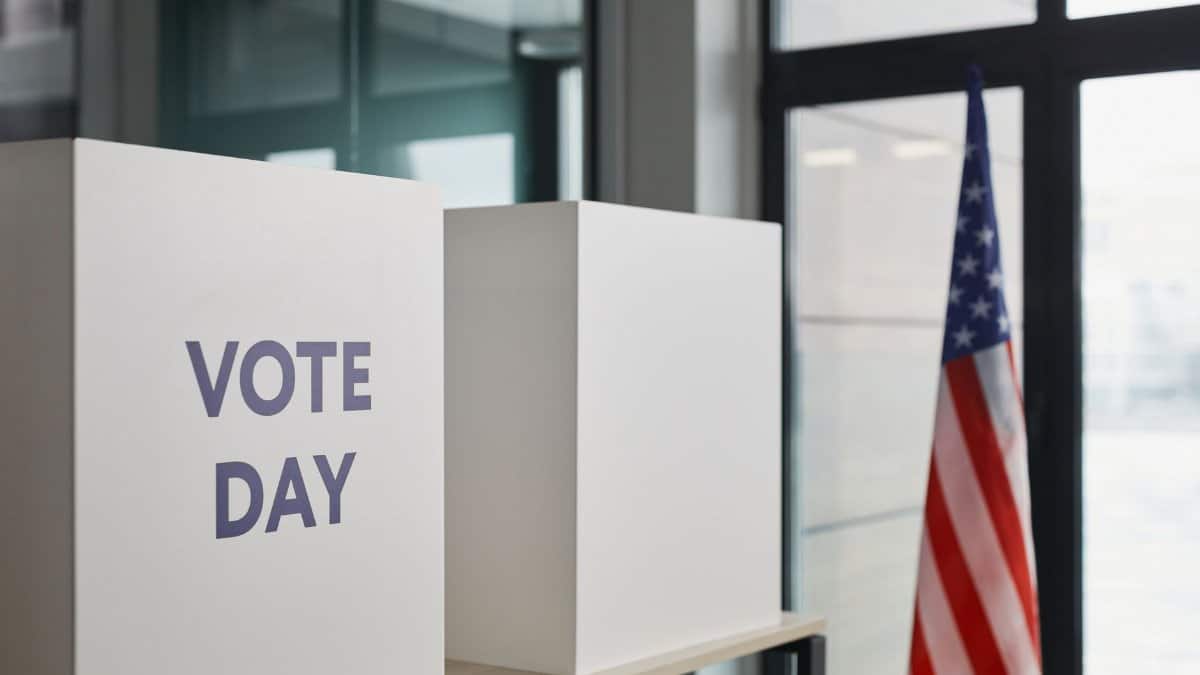 Voting booth setup with American flag, symbolizing election day.
