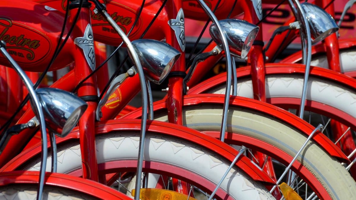 Detailed view of vibrant red vintage bicycles with chrome accessories and white tires.
